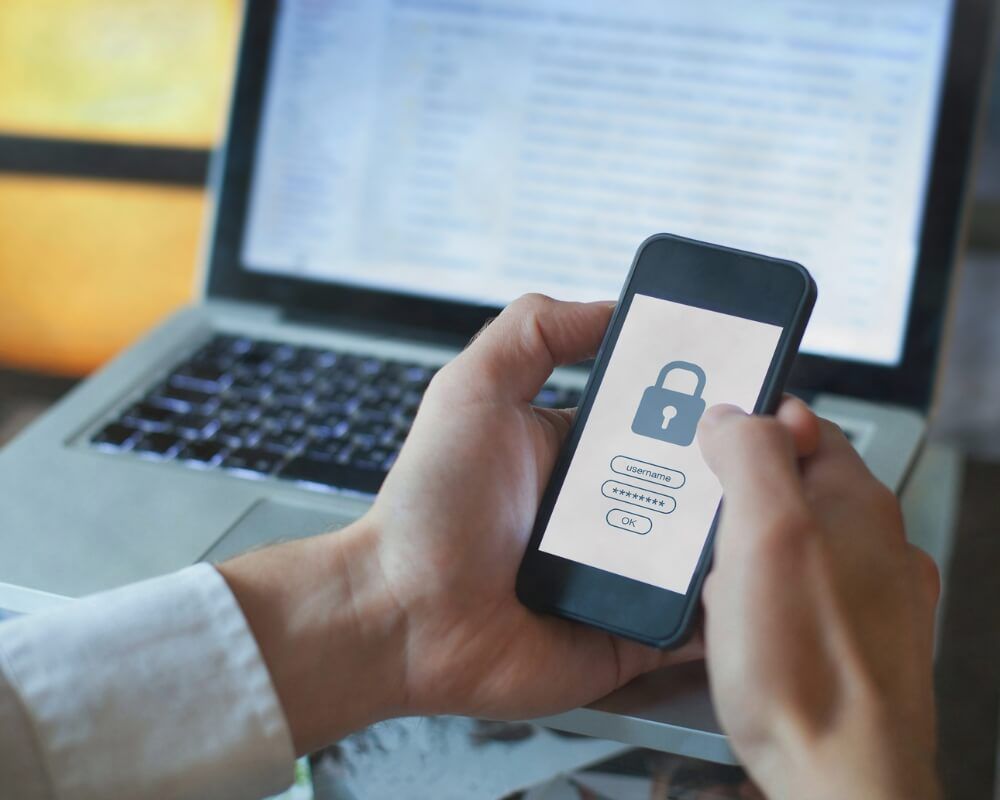screenshot of a person holding cellphone with password padlock on the screen
