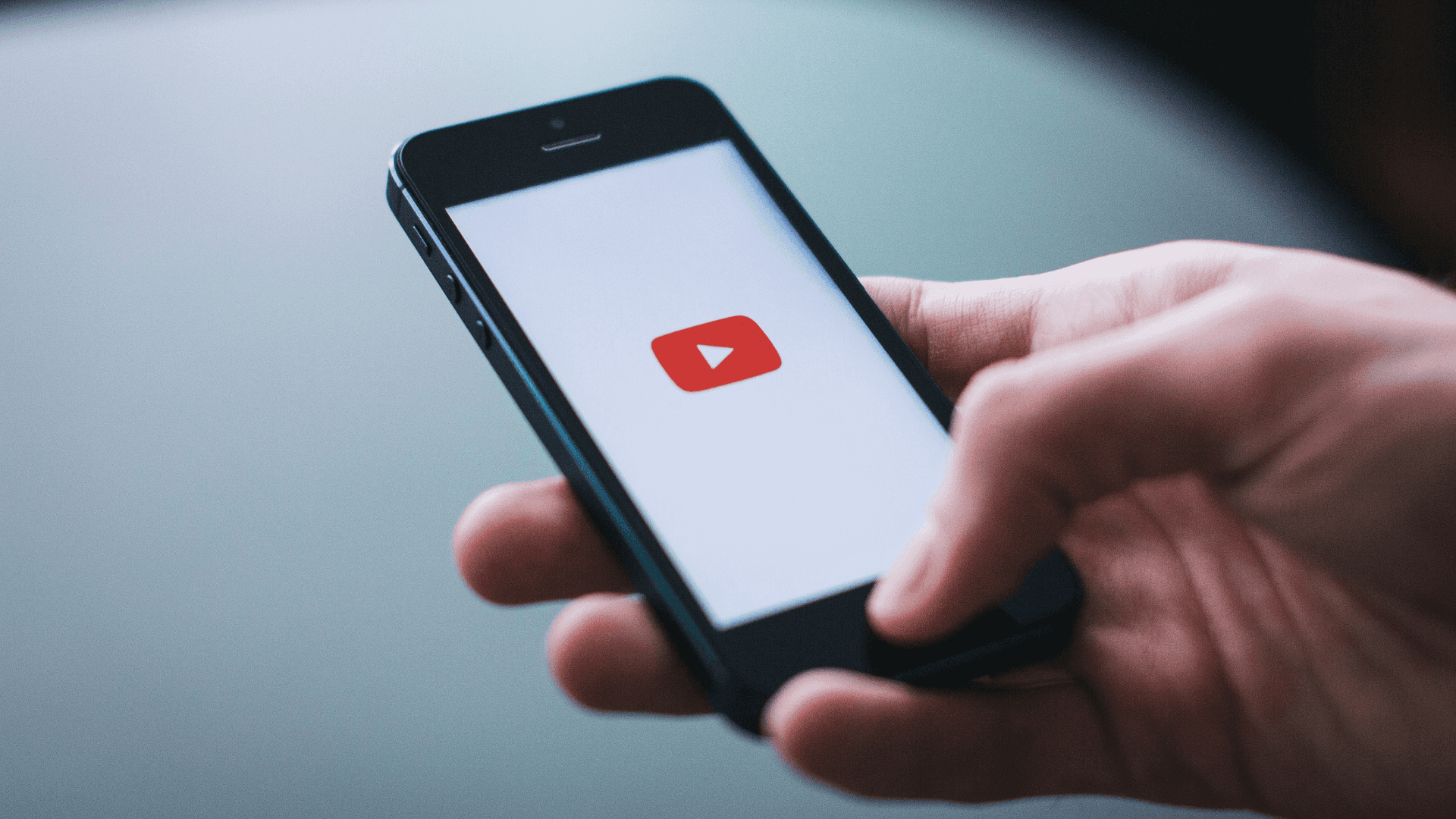 Smart phone with a YouTube logo on it, representing solving YouTube playback errors on mobile devices.