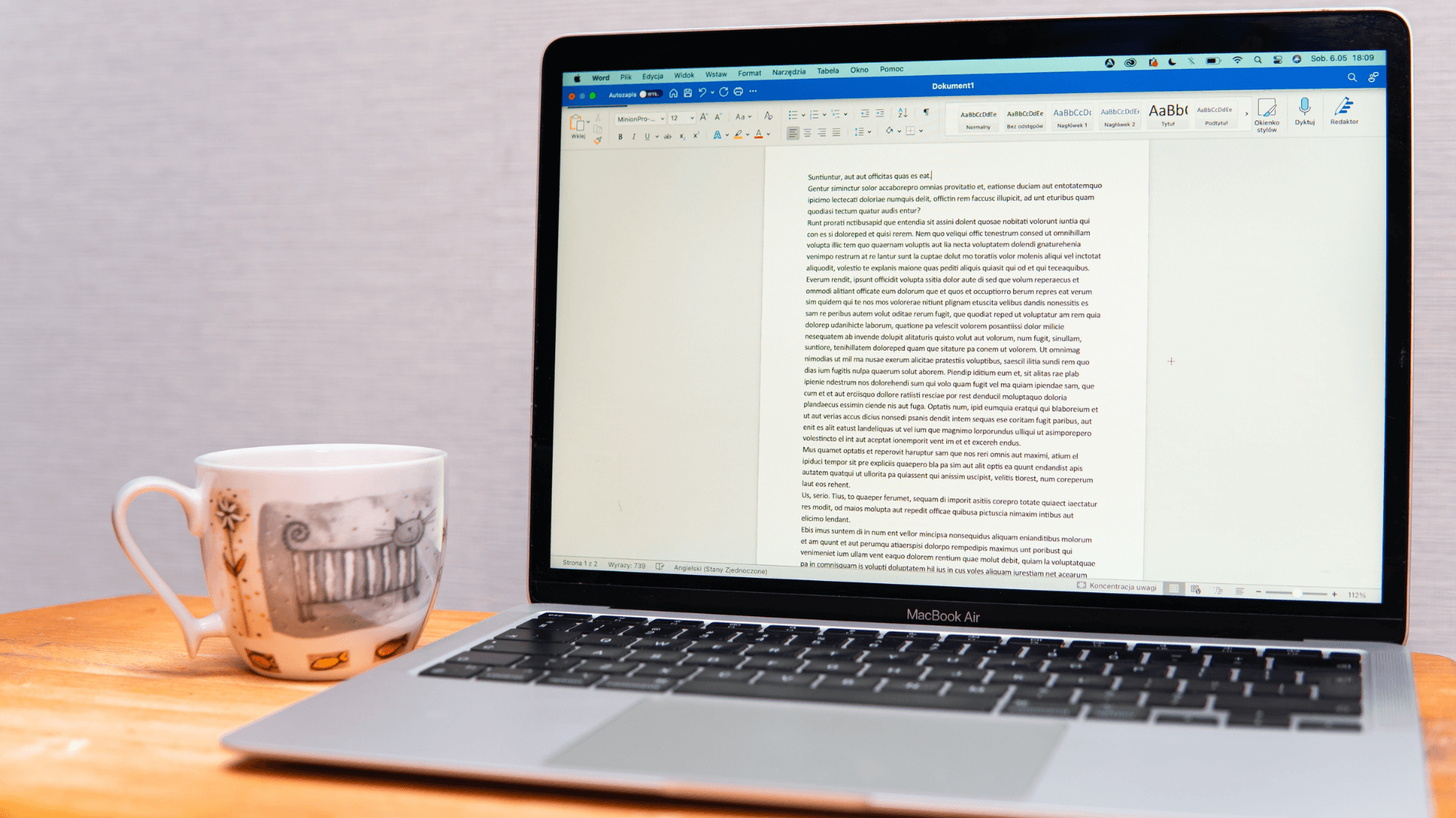 Computer with a Word document on it and a coffee mug next to it, representing the undo and redo shortcut on text processing apps
